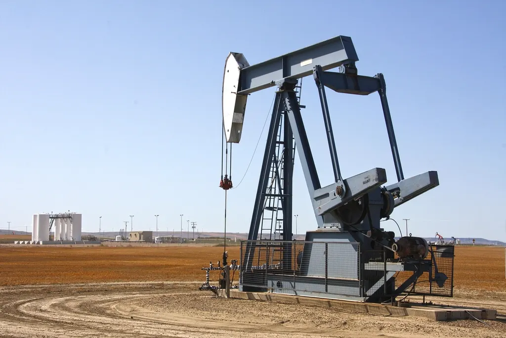Oil pump jack in an oilfield under a clear sky